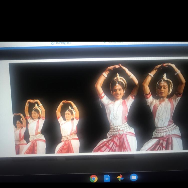 Look at the photo of modern Indian dancers performing a traditional dance.